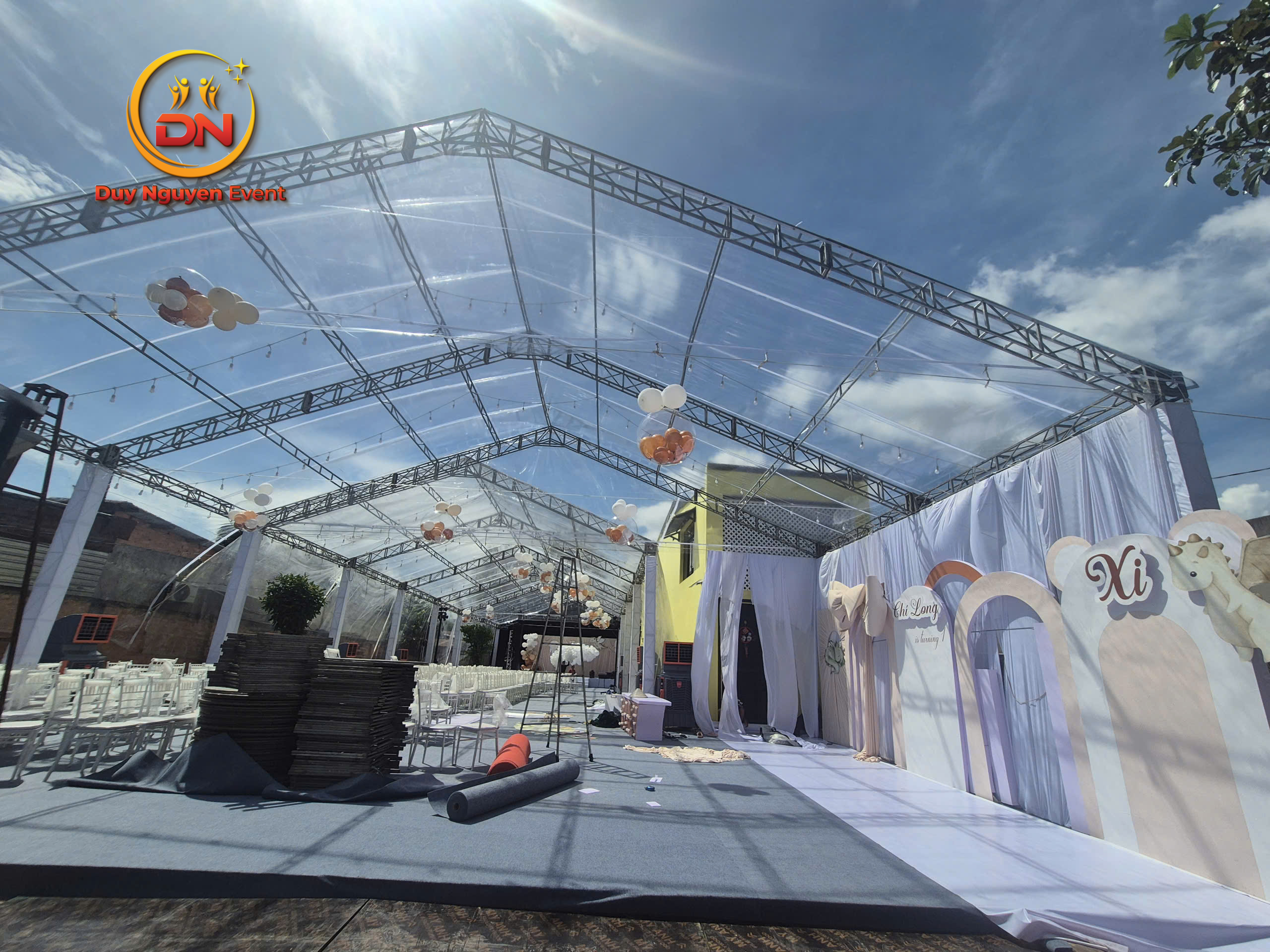 Ảnh chụp một nhà bạt trong suốt được trang trí đèn lộng lẫy cho đám cưới tối.