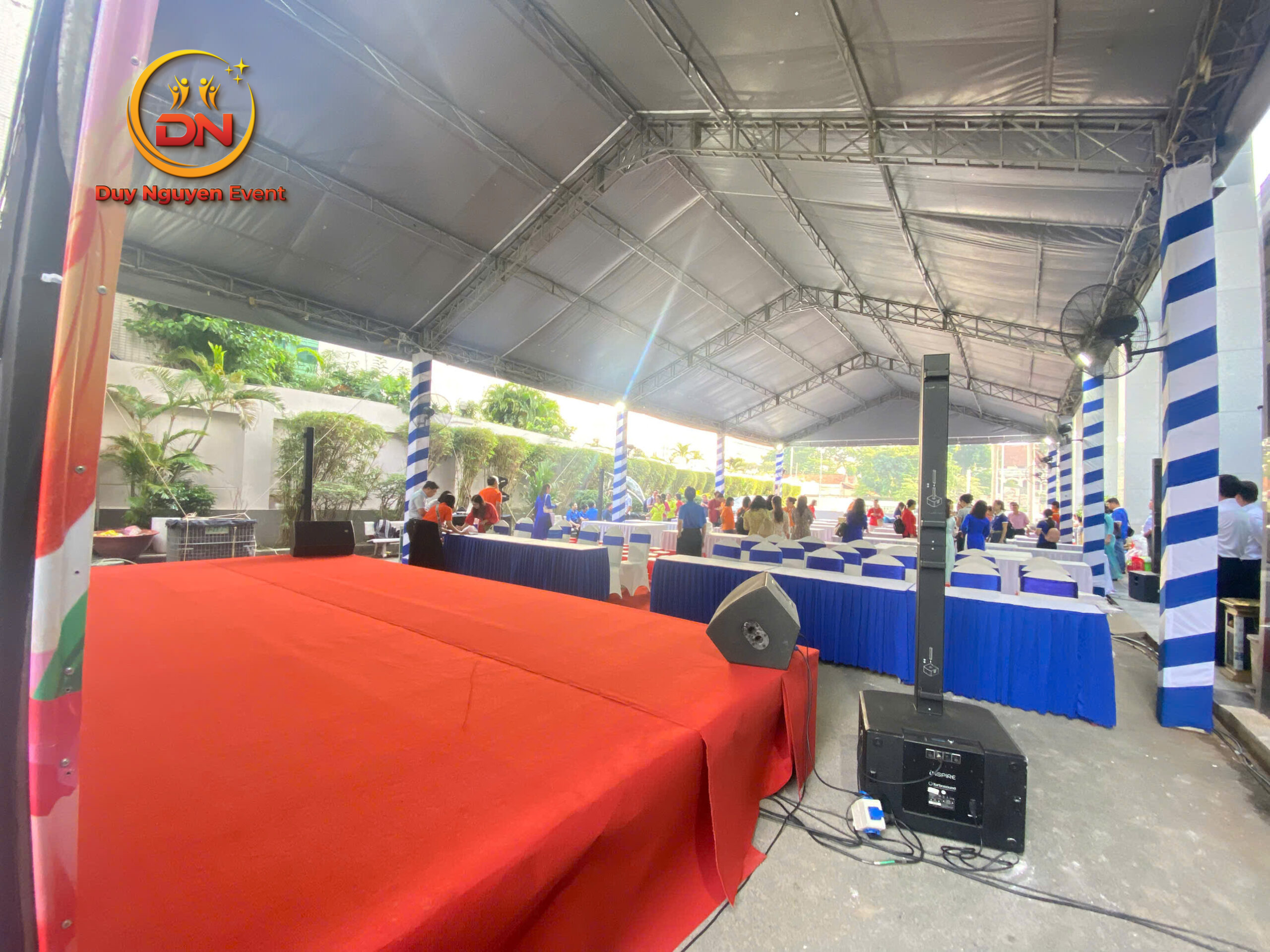 Sân khấu lễ khai trương trang trọng với thảm đỏ và bục phát biểu