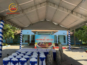 Hình ảnh toàn cảnh một sự kiện lớn (Lễ khởi công hoặc Tiệc cưới) sử dụng nhà bạt không gian đẹp, trời xanh, có logo Duy Nguyễn.