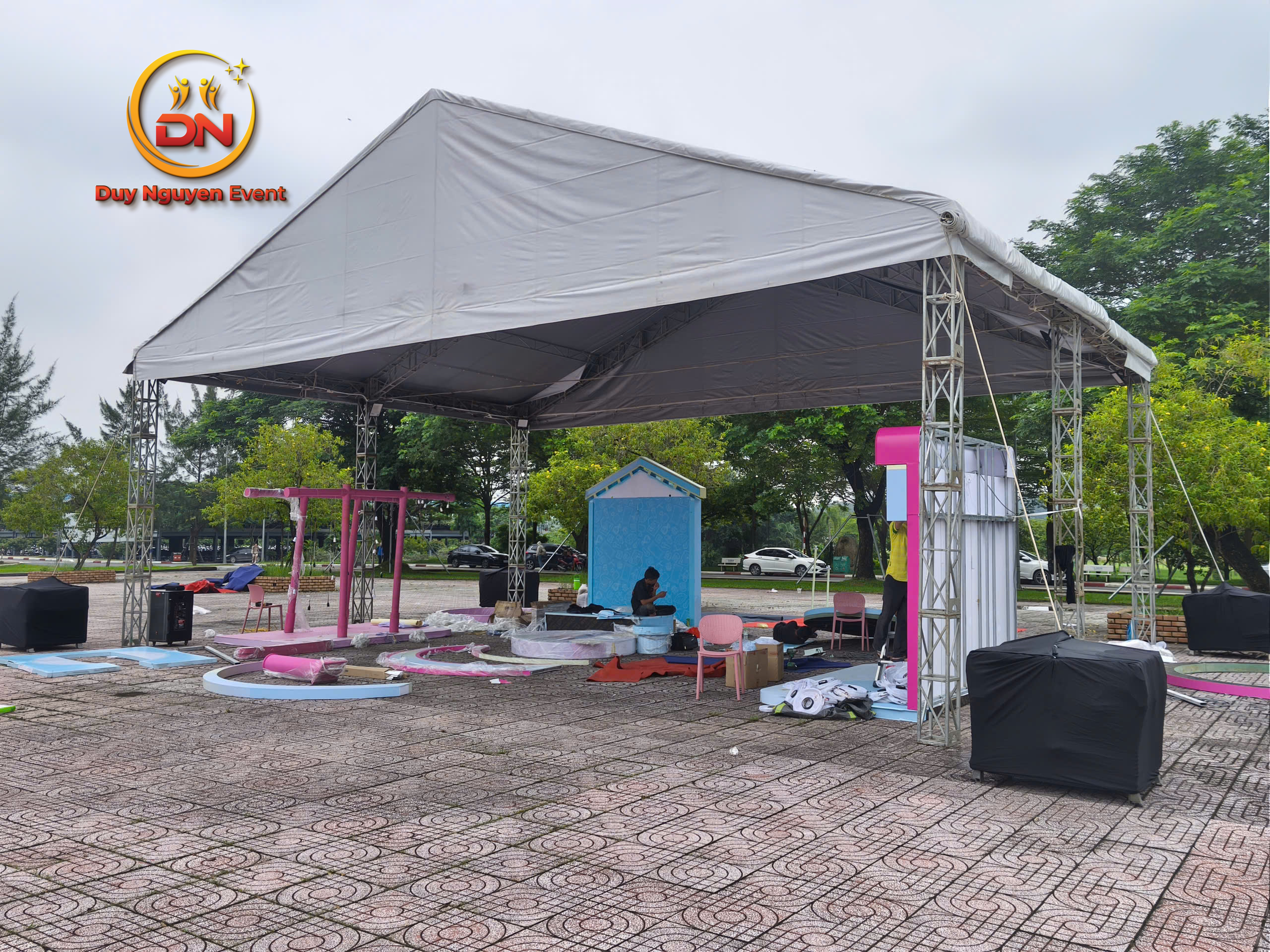 Nhân viên đang lắp khung, đang căng bạt, xe tải chở đồ